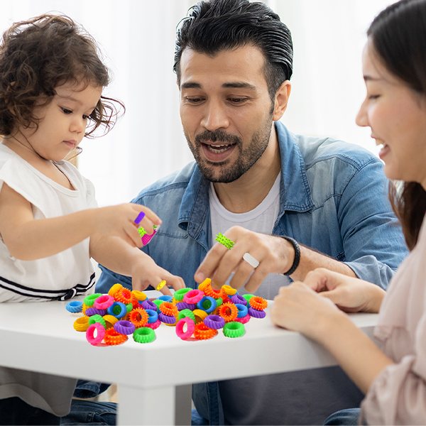 A family trying KLT fidget rings together at the table